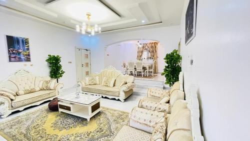 a living room with white couches and a table at House 5 in Ilorin