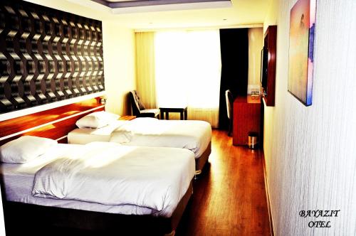 a hotel room with two beds and a window at Bayazıt Hotel in İskenderun