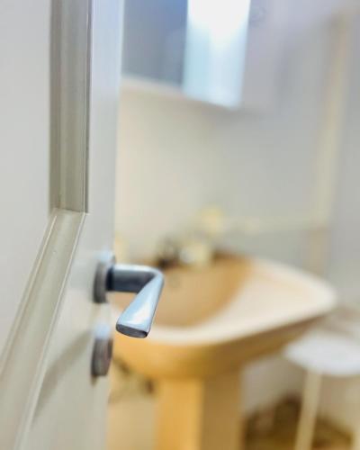 a doorhandle to a bathroom with a sink at SHUBY HOME in San Pietro Vernotico