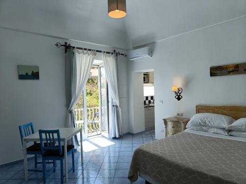 a bedroom with a bed and a table and a window at Regina Margherita in Positano