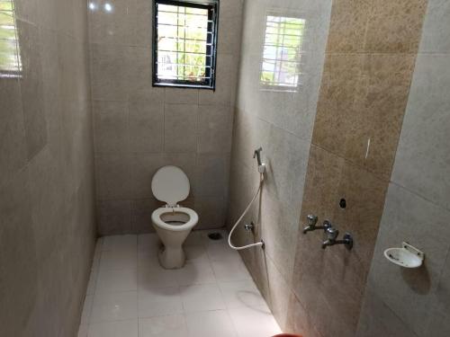łazienka z toaletą i oknem w obiekcie Aditya palace w mieście Shirdi