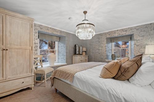 a bedroom with a large bed and a chandelier at Cathedral House in Dornoch