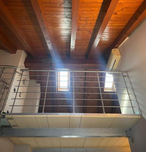 an empty staircase in a building with wooden ceilings at FilandaLago Apartment in Iseo