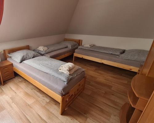 three beds in a room with wooden floors at Penzion Pod Zámkem in Vizovice