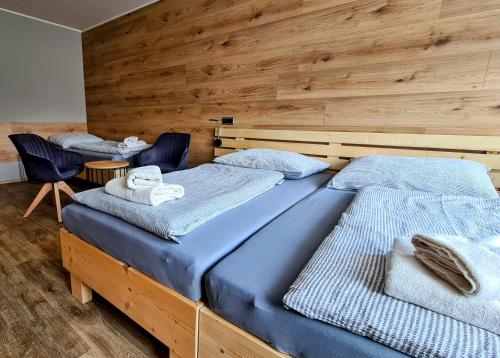 two twin beds in a room with wooden walls at Penzion Pod Zámkem in Vizovice