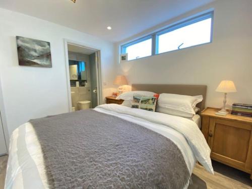 a bedroom with a large bed and a window at Stunning architect designed beachfront property in Selsey