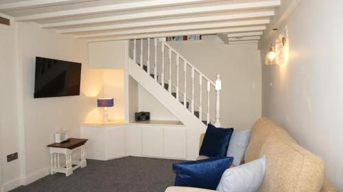 un soggiorno con un divano e una scala di Wheat Cottage - 5* Cyfie Farm with private covered hot tub a Llanfyllin