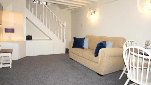 a living room with a couch and a staircase at Wheat Cottage - 5* Cyfie Farm with private covered hot tub in Llanfyllin