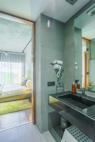 a bathroom with a sink and a bedroom with a bed at Résidence Galilée - Gauthier in Casablanca