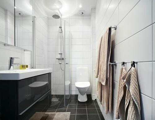 y baño con aseo, lavabo y ducha. en Wow Apartments Örgryte en Gotemburgo