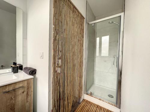 une salle de bain avec une douche avec une porte vitrée dans l'établissement Ô Bien-Être, à Morlaix