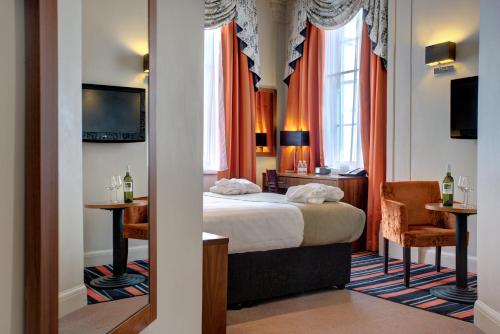 um quarto de hotel com uma cama, uma secretária e uma cadeira em Heywood House Hotel, BW Signature Collection em Liverpool