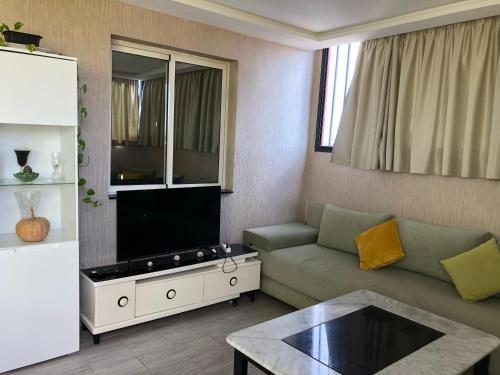 a living room with a couch and a tv at ANE in Rabat