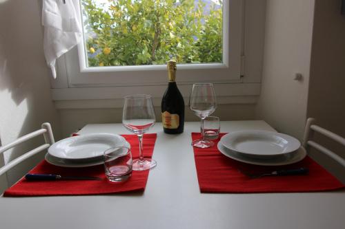 a table with plates and glasses and a bottle of wine at Casa Melina 2 in Tremezzo