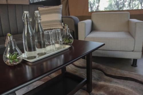 a living room with a table with glass bottles on it at Drunken Elephant Mara in Sekenani
