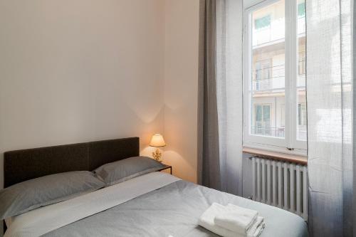 Schlafzimmer mit einem großen Bett und einem Fenster in der Unterkunft Teatro Ariston & Piazza Colombo Elegant Apartment in Sanremo