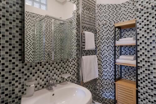 ein Bad mit einem Waschbecken und einem Spiegel in der Unterkunft Teatro Ariston & Piazza Colombo Elegant Apartment in Sanremo