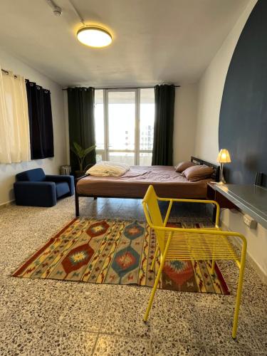 a bedroom with a bed and a yellow chair and a rug at Bethlehem City Hostel in Bethlehem