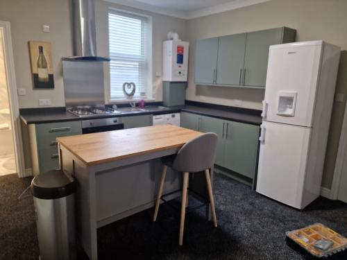 a kitchen with a wooden table and a refrigerator at Levy Nook 3 in Darlington