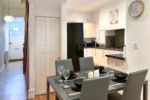 a kitchen with a table with chairs and a dining room at Homely 4-bedroom House in Manchester