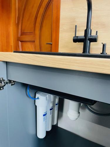 a kitchen sink with pipes under a counter at BRIVIBAS RESIDENCE - WEST / EAST, free PRIVAT parking, free WIFI, self check-in in Rīga