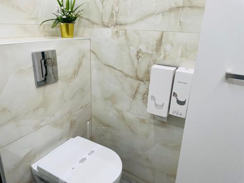 a bathroom with a white toilet and a sink at BRIVIBAS RESIDENCE - WEST / EAST, free PRIVAT parking, free WIFI, self check-in in Rīga