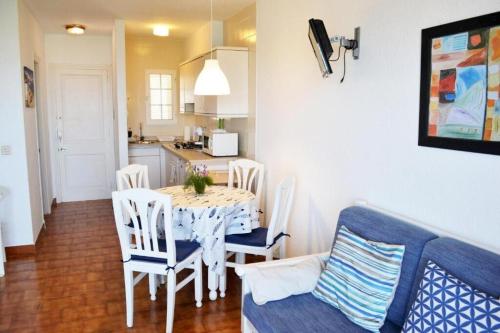 cocina y comedor con mesa y sillas en Apartamento Castellsol 105., en Arenal d'en Castell