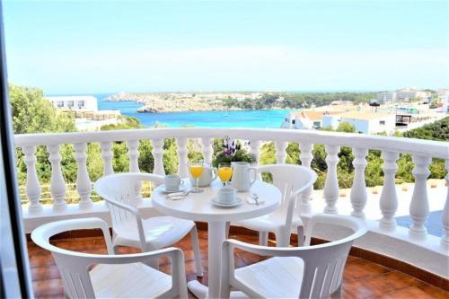 una mesa blanca y sillas en un balcón con vistas en Apartamento Castellsol 105., en Arenal d'en Castell