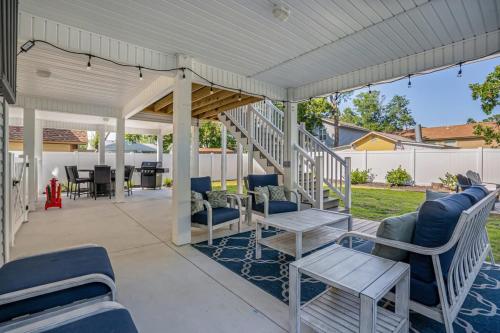 a porch with blue chairs and a table and a white roof at Charming Beach House Short Walk To Beach in Myrtle Beach