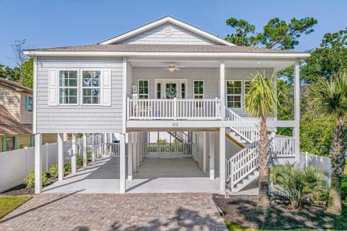 a white house with a white porch and a house at Charming Beach House Short Walk To Beach in Myrtle Beach
