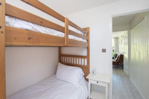 een slaapkamer met een stapelbed en een wit laken bij Chalet Thirtyone in Deal