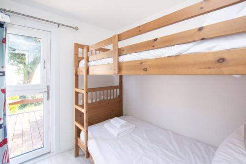 a bedroom with two bunk beds and a window at Chalet Thirtyone in Deal
