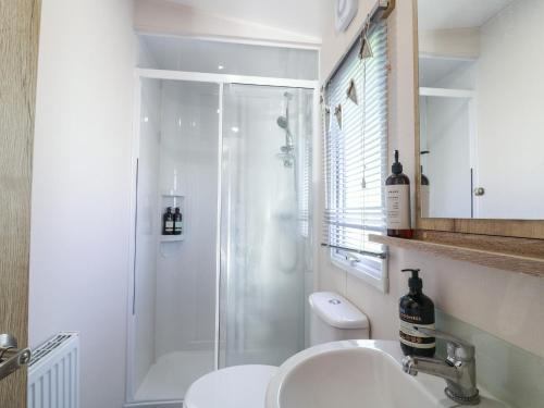 uma casa de banho com um chuveiro e um lavatório. em Seasalt em West Mersea
