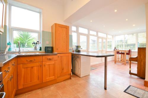 a kitchen with wooden cabinets and a table in it at St Georges Villa in Ryde