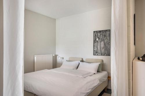 ein Bett mit weißer Bettwäsche und Kissen in einem Schlafzimmer in der Unterkunft Ferienwohnung Zwei in Saal