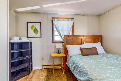 a bedroom with a bed and a table and a window at The Cozy Cottage by the Ocean in Hampton