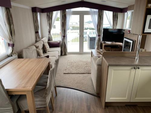 a living room with a couch and a table at Beautiful sea view 3 bedroomed Holiday Home Caravan in Exmouth