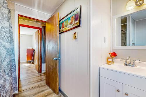 La salle de bains est pourvue d'un lavabo et d'un miroir. dans l'établissement The Cozy Cottage by the Ocean, à Hampton Beach