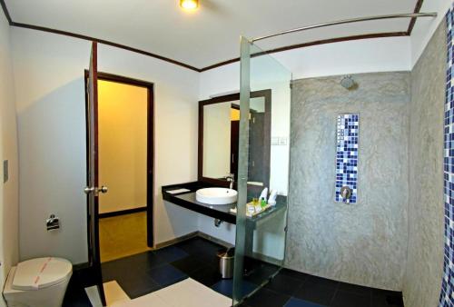 uma casa de banho com um lavatório e uma cabina de duche em vidro. em Rathna Beach Wadduwa em Kalutara