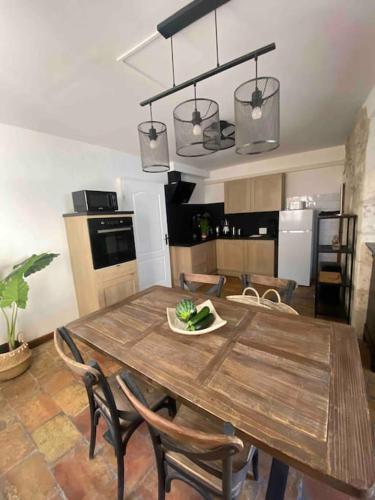 une cuisine avec une table en bois et des chaises ainsi qu'une salle à manger dans l'établissement Grand duplex lumineux-hyper centre, à Arles
