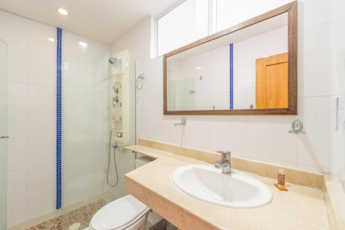 uma casa de banho com um lavatório, um WC e um espelho. em Basic Hotel Centenario by Hoteles MS em Cali