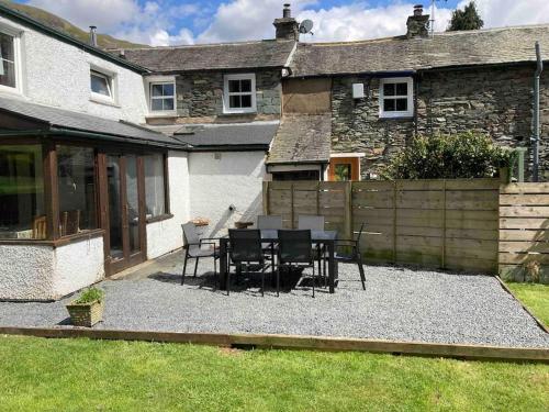 a patio with a table and chairs in front of a house at The Old Smithy, Ullswater in Glenridding