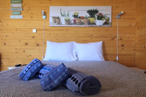 Una cama con almohadas azules y plantas. en Monte Sardinha, en Santiago do Cacém