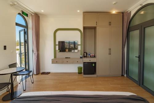 a bedroom with a bed and a table and a mirror at Storij Home & Coffee in Khu Chi Lăng