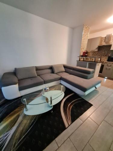 un salon avec un canapé et une table en verre dans l'établissement Apt cosy village olympique, à Saint-Ouen