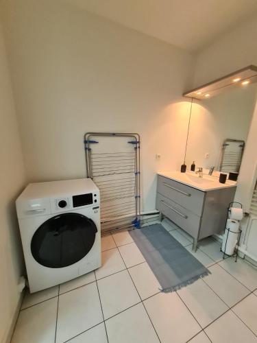 een keuken met een wasmachine en een wastafel bij Apt cosy village olympique in Saint-Ouen