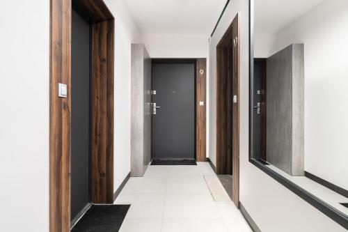 a hallway with a row of doors and white tiles at Apartament przy Koscielnej in Poznań