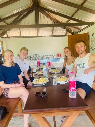 a group of people sitting around a wooden table at White Villa Kitulgala in Kitulgala