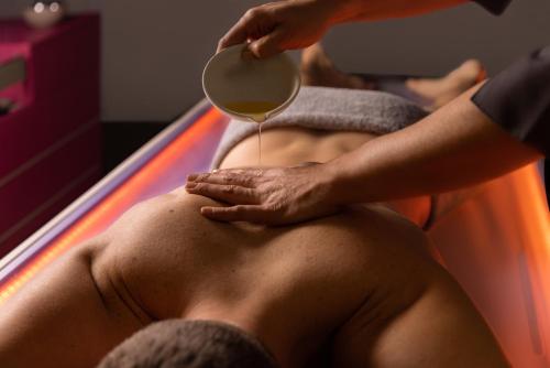 un hombre en un jacuzzi recibiendo un masaje en Margaida Boutique Hotel & SPA, en Cala Gonone