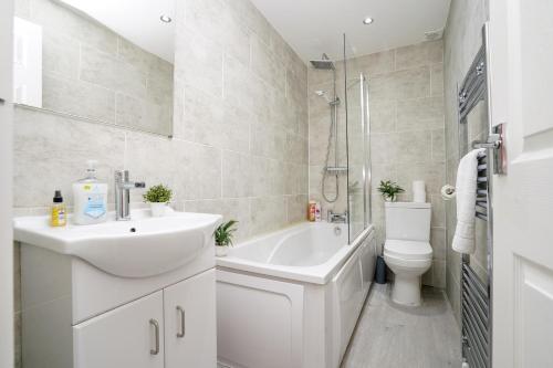 a white bathroom with a sink and a toilet at Beautiful House with Parking in Wibsey